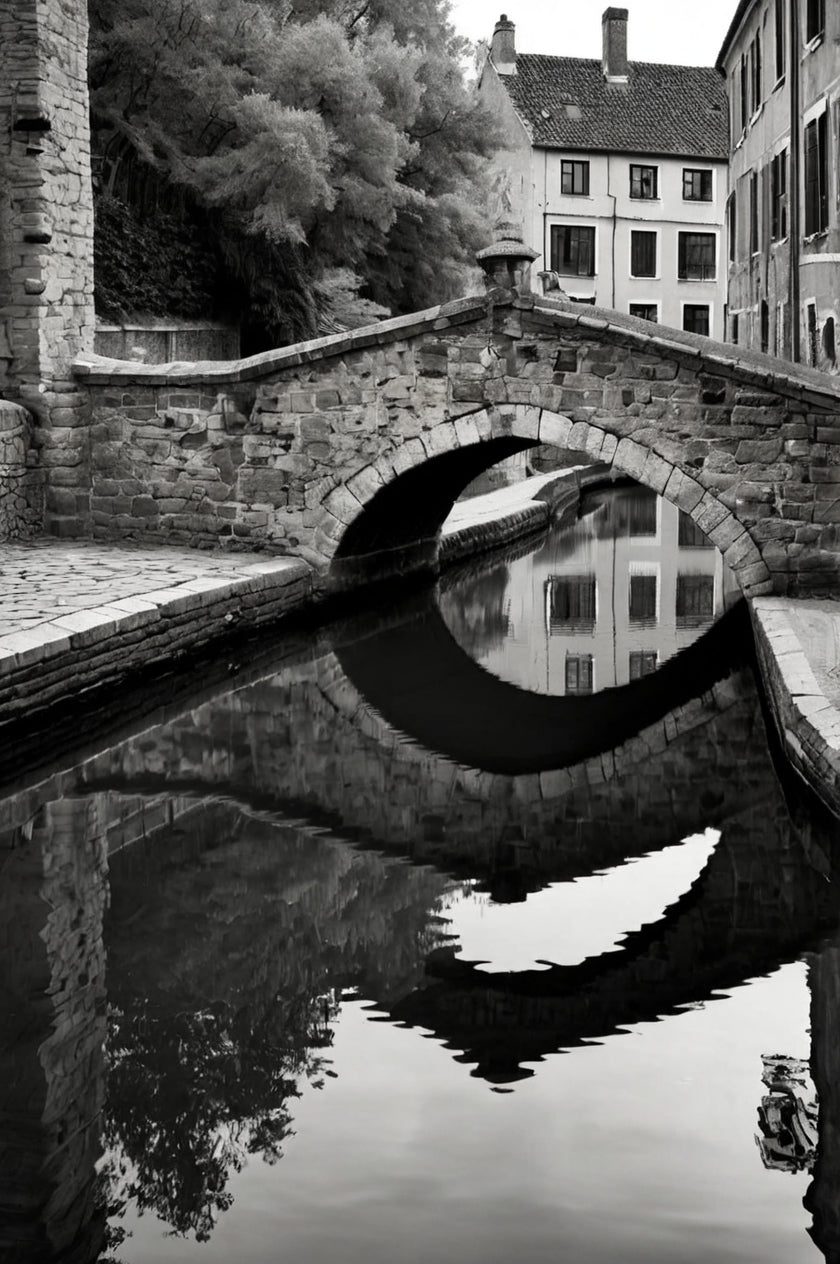 Old stone arch bridge over calm water with reflection (black & white)